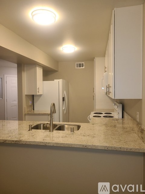 A kitchen with granite countertops and white cabinets.