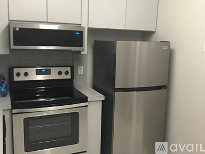 A modern kitchen with a stainless steel refrigerator and oven.