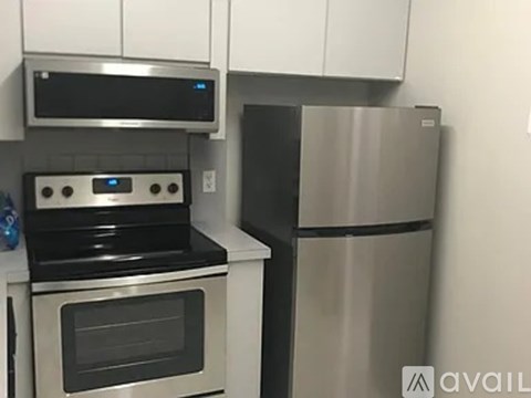A modern kitchen with a stainless steel refrigerator and oven.