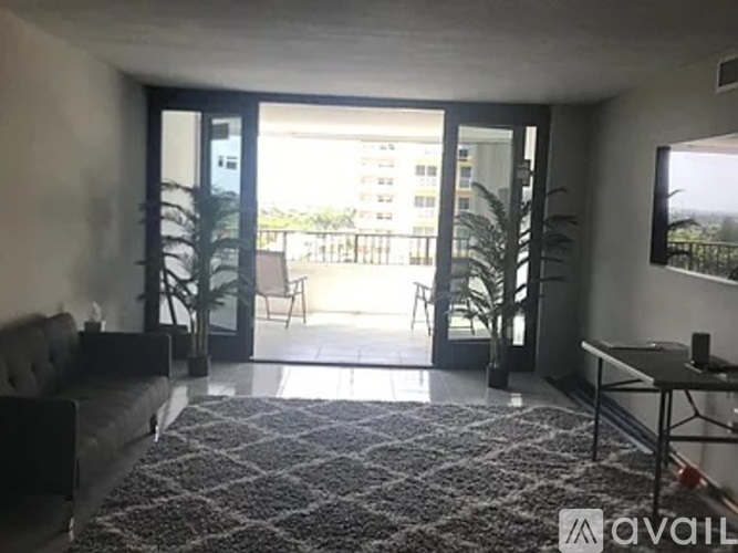 A living room with a grey sofa and a black and white patterned rug.