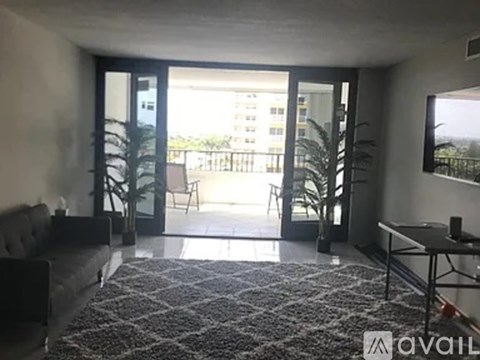 A living room with a grey sofa and a black and white patterned rug.