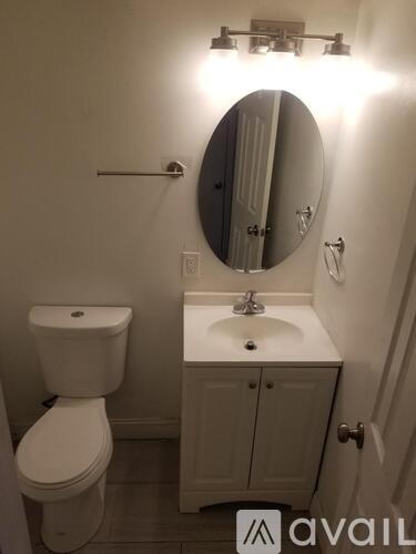 A white toilet and sink in a small bathroom.