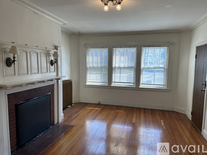 A room with a fireplace and wooden floors is available for rent.