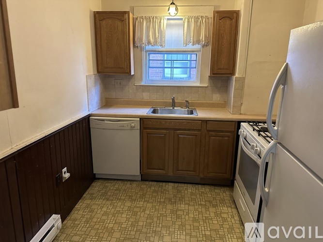 A kitchen with a dishwasher, sink, and refrigerator.