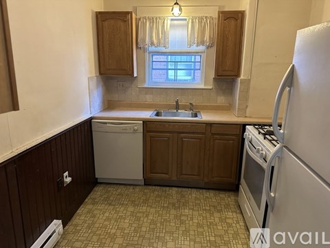 A kitchen with a dishwasher, sink, and refrigerator.