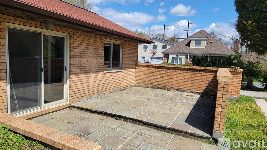 A backyard with a patio and a brick wall.