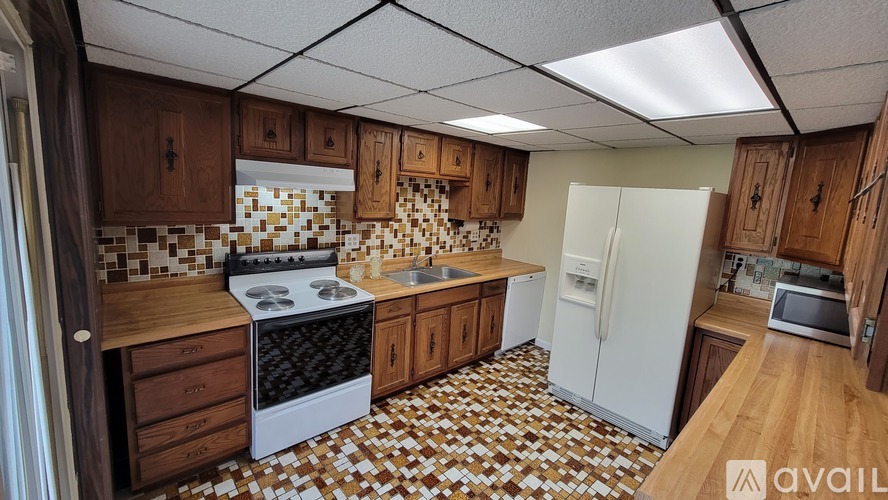 A kitchen with brown cabinets and a white fridge.