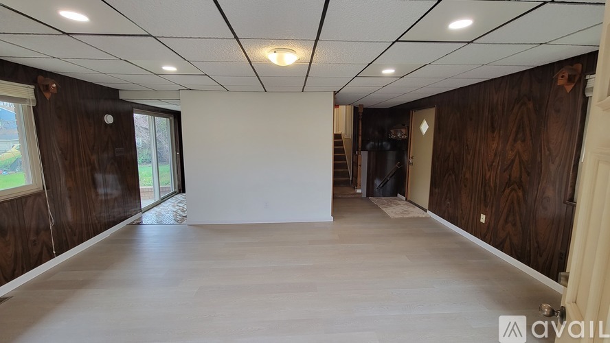 A spacious room with wooden walls and a white floor.