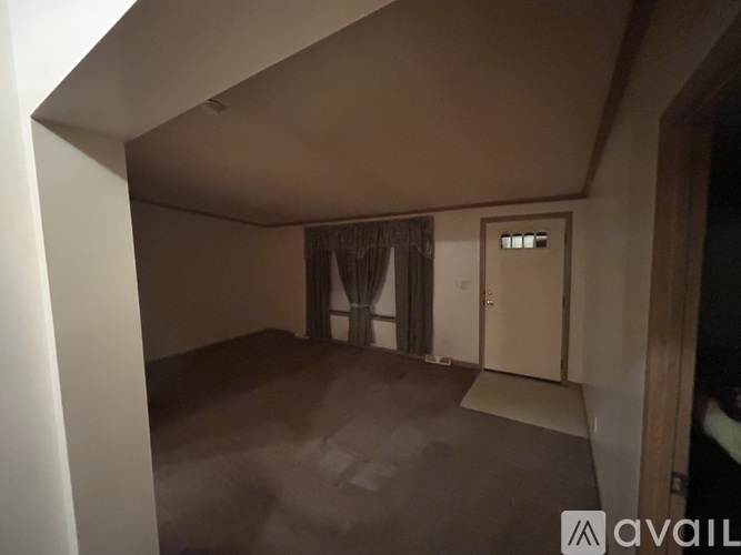 A room with a brown carpet and a white door.