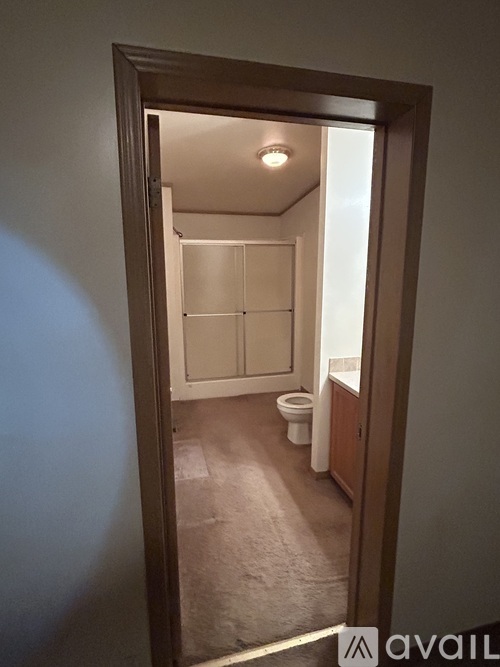 A bathroom with a toilet and sink is visible through an open door.