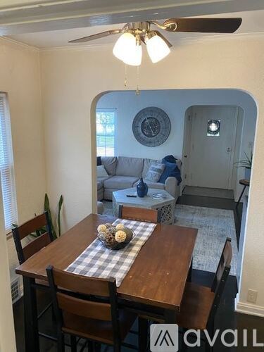 A dining room with a wooden table and chairs.