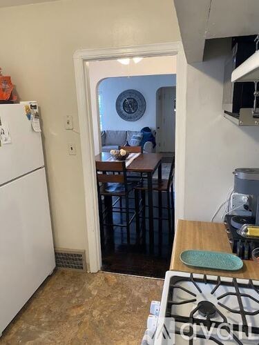 A kitchen with a white fridge and a stove top.