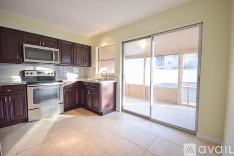 A kitchen with dark brown cabinets and stainless steel appliances.