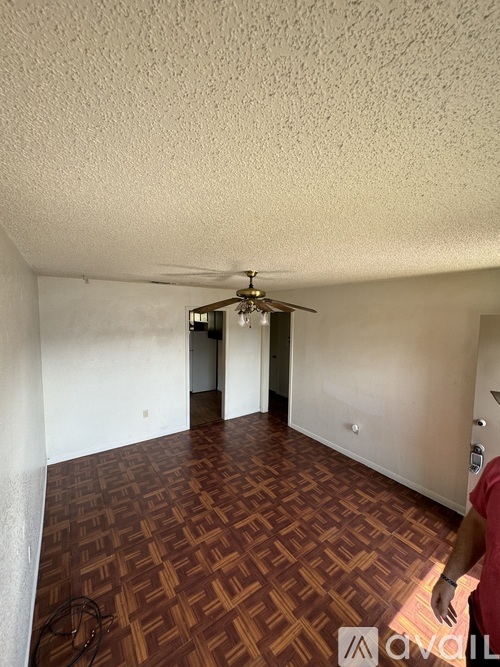 A room with a ceiling fan and a patterned floor.