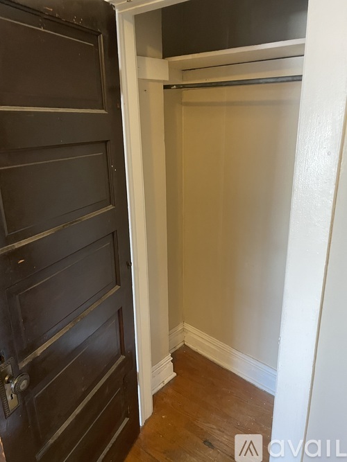 A black door is open to a white hallway.