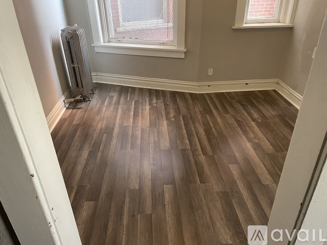 A room with wooden flooring and a window.