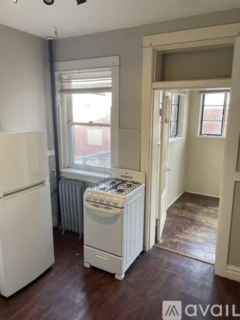 A kitchen with a white fridge and a white stove with a window behind it.