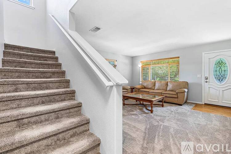 A staircase with a carpeted floor and a couch in the background.