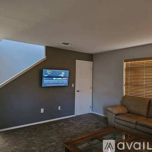 A living room with a flat screen TV mounted on the wall.