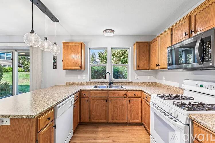 A kitchen with wooden cabinets and a white stove top oven.