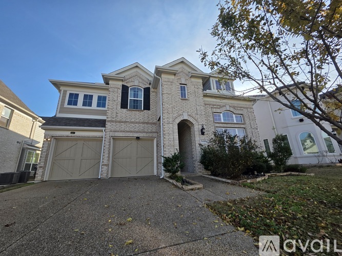 A two-story house with a garage and a driveway.
