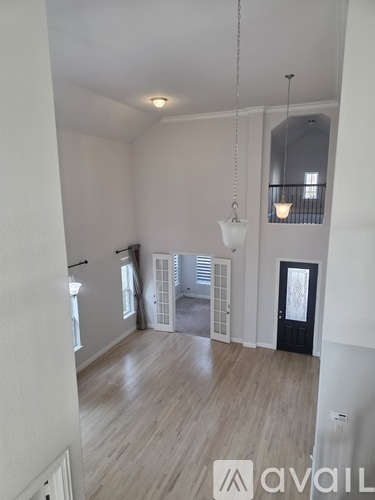 A large, empty room with wooden floors and white walls.