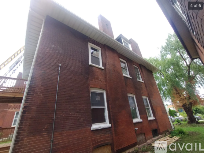 A red brick building with a white window and a black pole in front of it.
