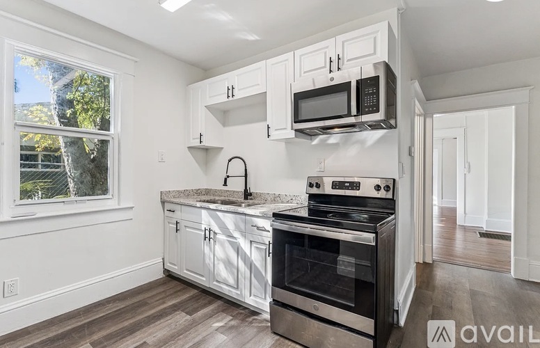 A kitchen with white cabinets and a stainless steel oven.