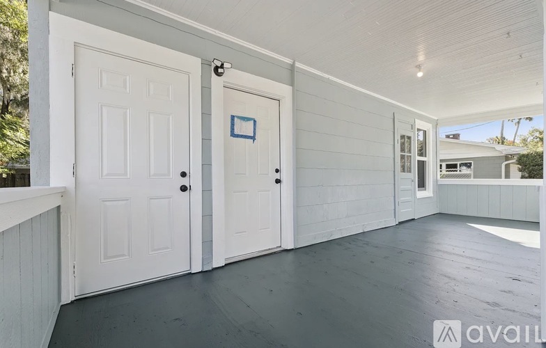 A white door with a blue square on it is on the right side of a white wall.