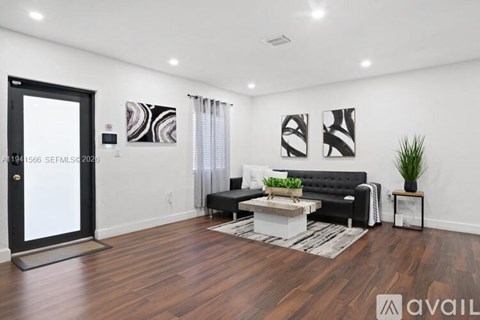 A living room with a black couch and a coffee table.