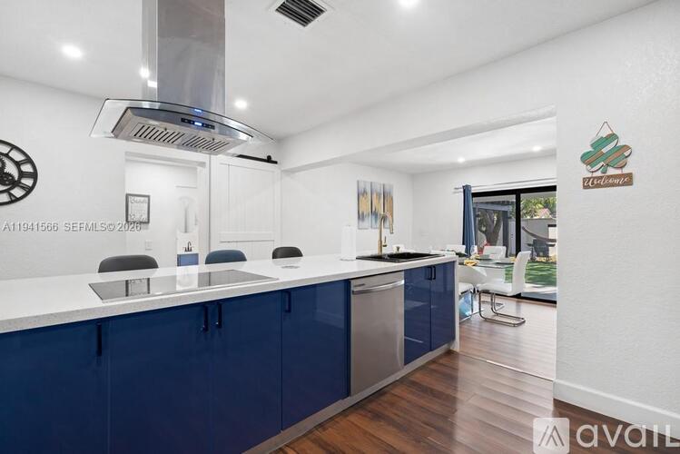 A kitchen with blue cabinets and a white countertop.