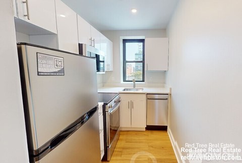 A kitchen with a refrigerator that has a sticker on it that says "Scan or Review for Maintenance".