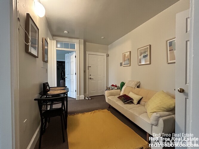 A living room with a couch, a chair, and pictures on the wall.