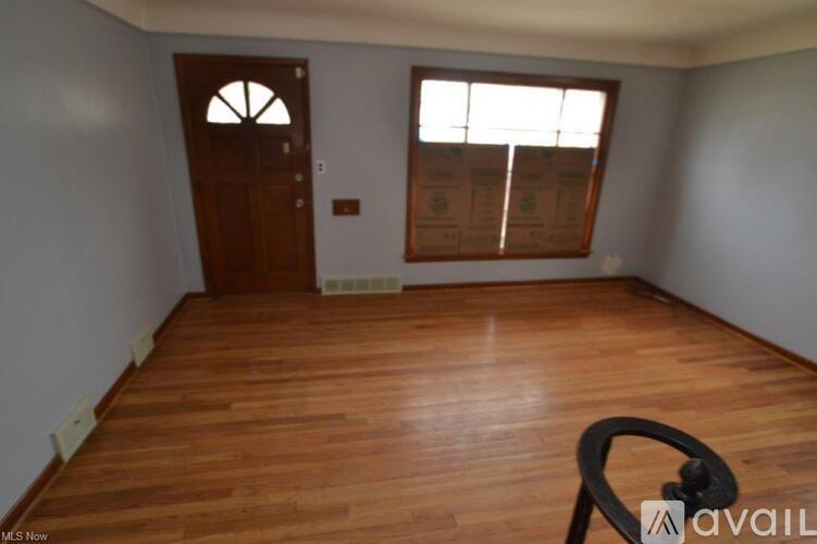 A room with wooden flooring and a door with a window above it.