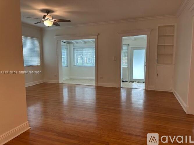A room with wooden floors and a ceiling fan.