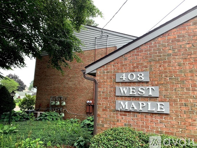 A brick building with a sign that says West Maple.