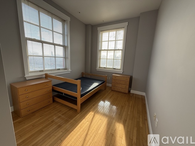 A bedroom with a bed, dresser, and nightstand.