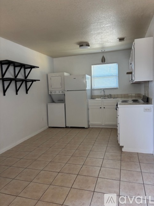 A kitchen with white appliances and beige cabinets.
