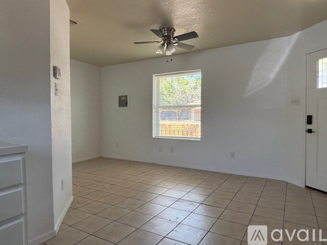 A room with a white door and a tiled floor.