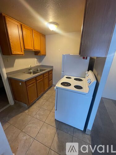 A kitchen with a white stove and wooden cabinets.