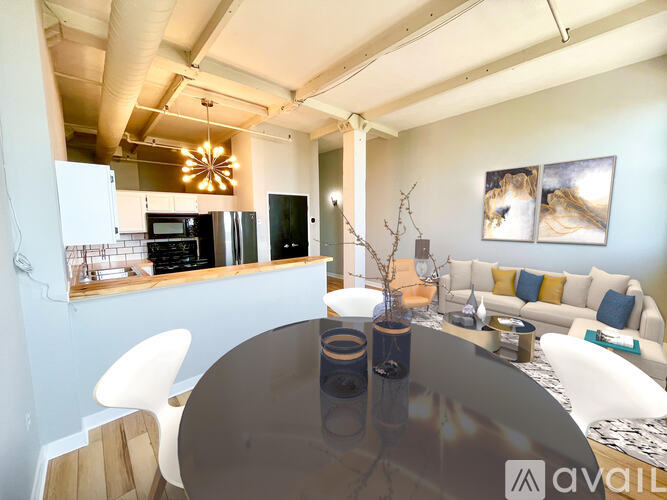 A modern kitchen with a glass table and white chairs.