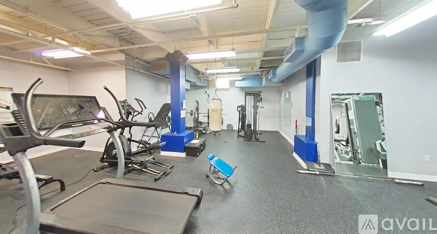 A gym with a variety of equipment including treadmills, weights, and exercise machines.