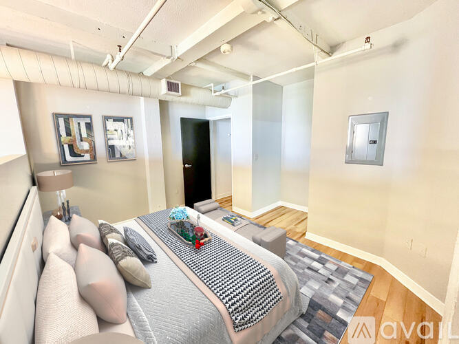 A bedroom with a bed, pillows, and a nightstand.