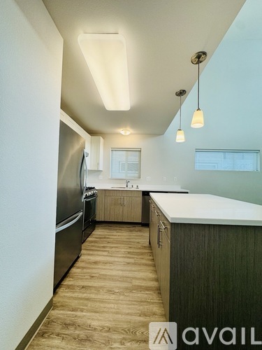 A kitchen with a refrigerator, oven, and cabinets.