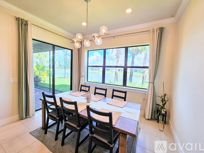 A dining room with a table set for four and a view of a garden outside.