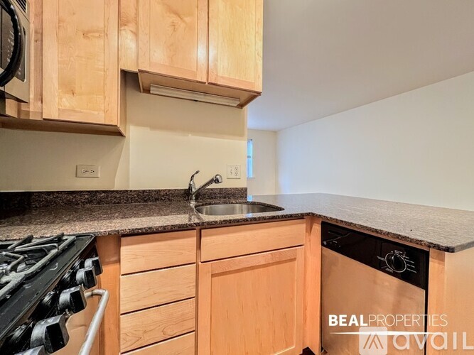 A kitchen with wooden cabinets and a black stove top.