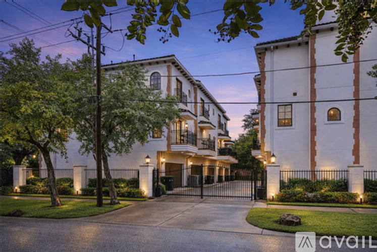A large, well-lit house with a driveway and a gated entrance.