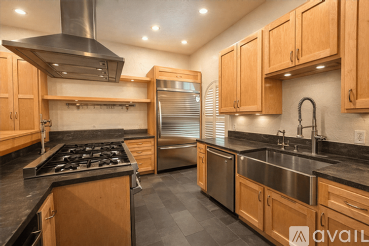 A modern kitchen with wooden cabinets and stainless steel appliances.