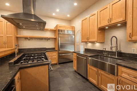 A modern kitchen with wooden cabinets and stainless steel appliances.