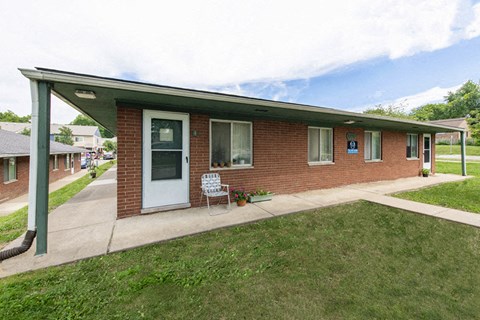 the front of a brick house with a porch